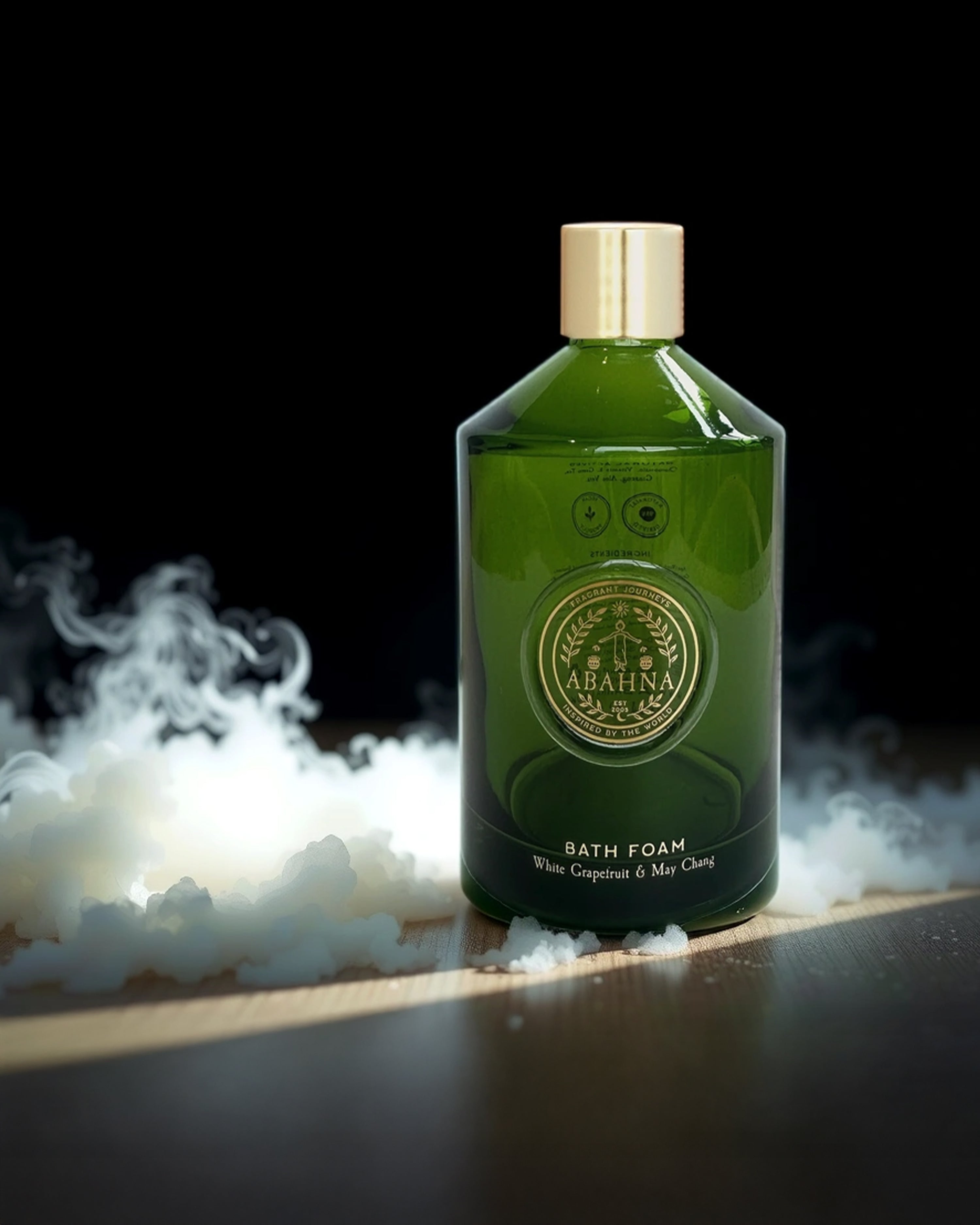 Green bottle of bath foam with gold cap on a dark background