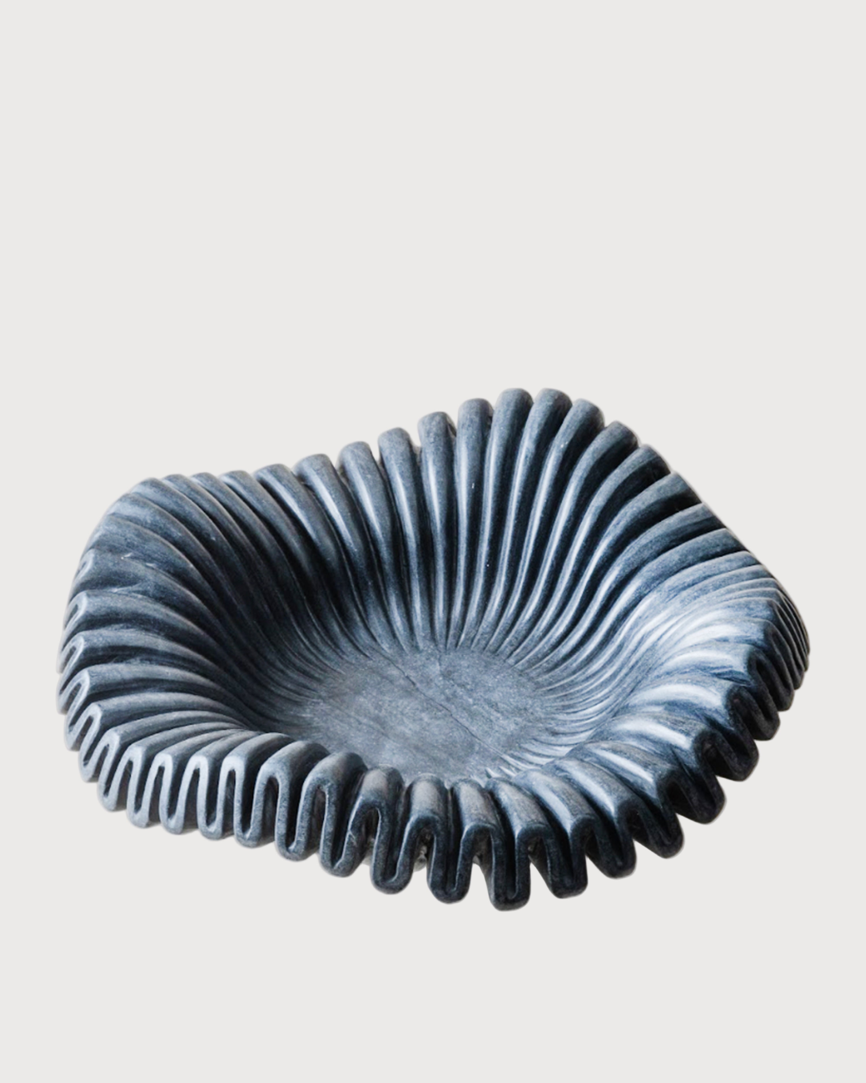 A handmade black marble bowl with a wavy edge design, displayed against a neutral background.