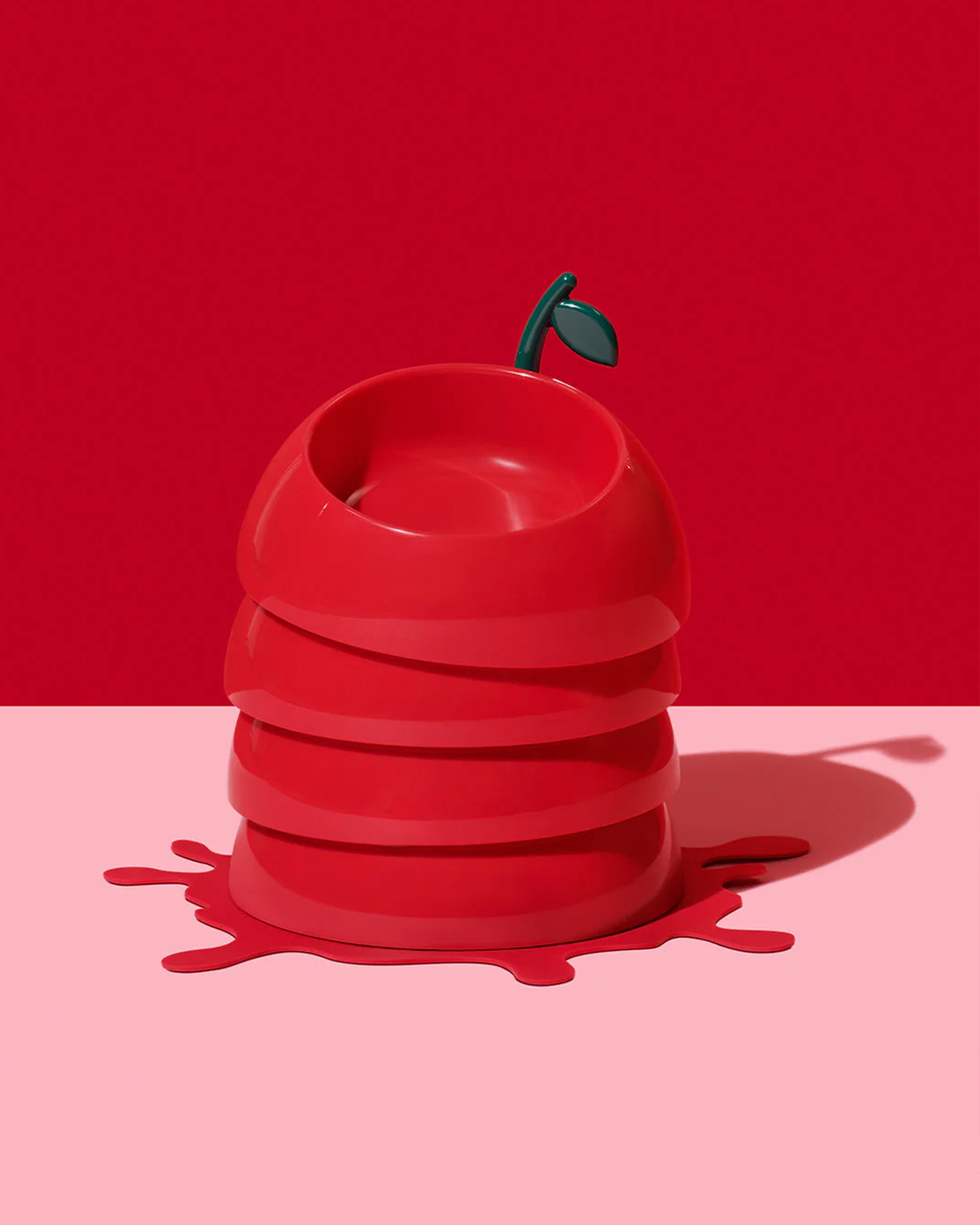 Red apple-shaped container with a green stem on a red background
