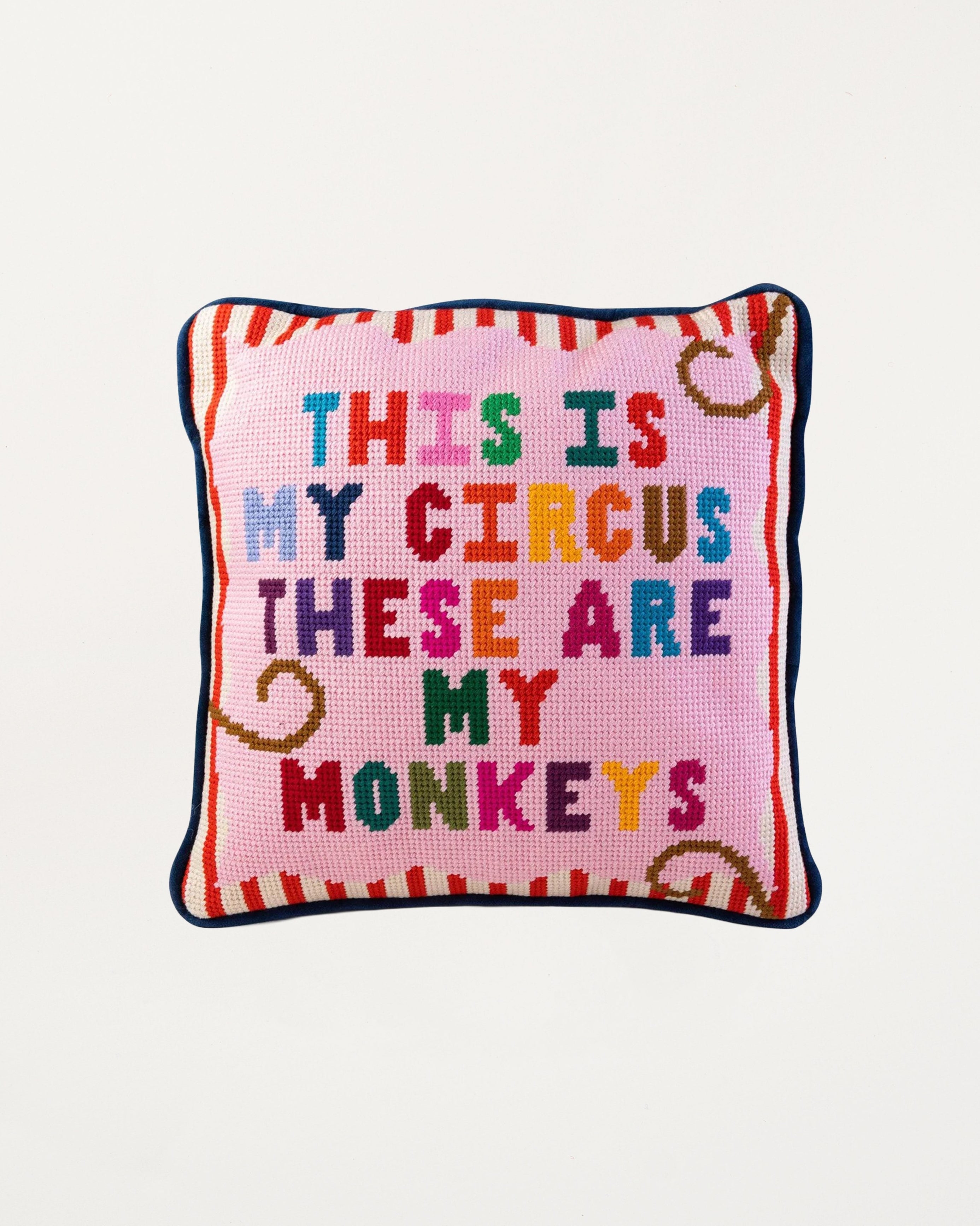 Decorative pillow with colorful text on a pink background