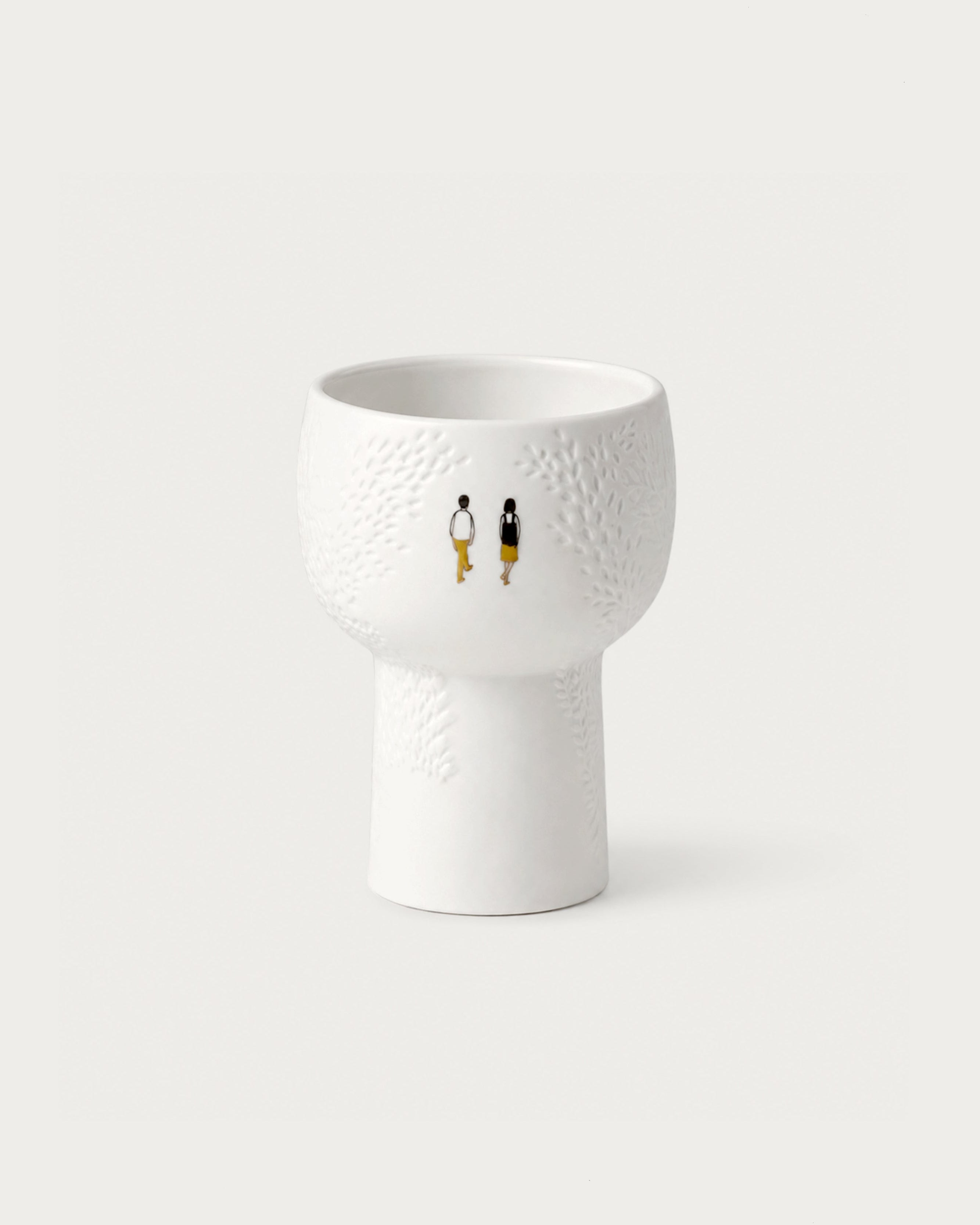 White textured ceramic vase with small figures on a light gray background