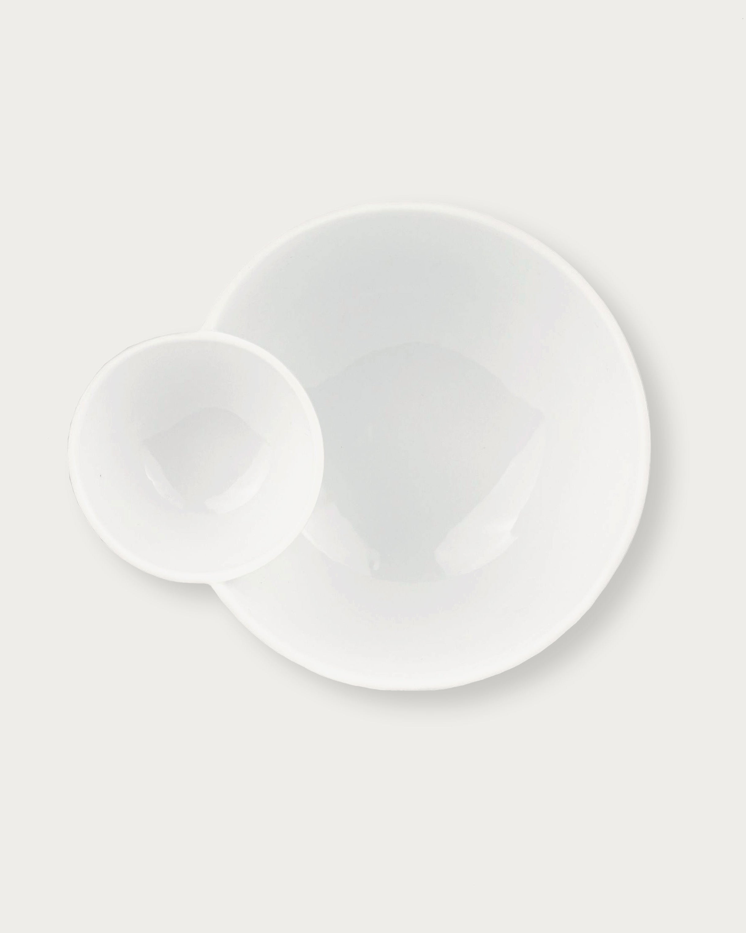 Two white ceramic plates on a light gray background