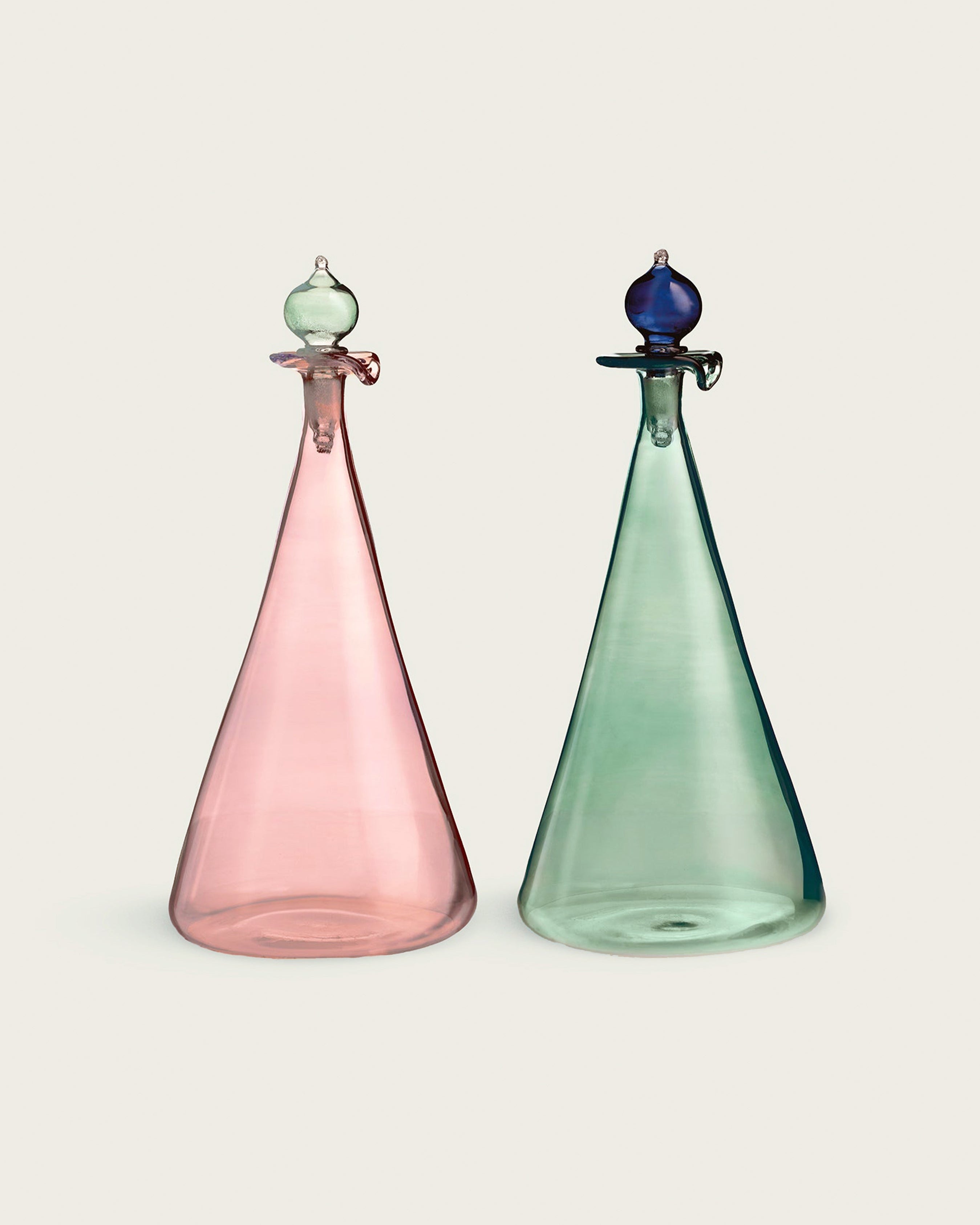 Two colorful glass decanters on a beige background