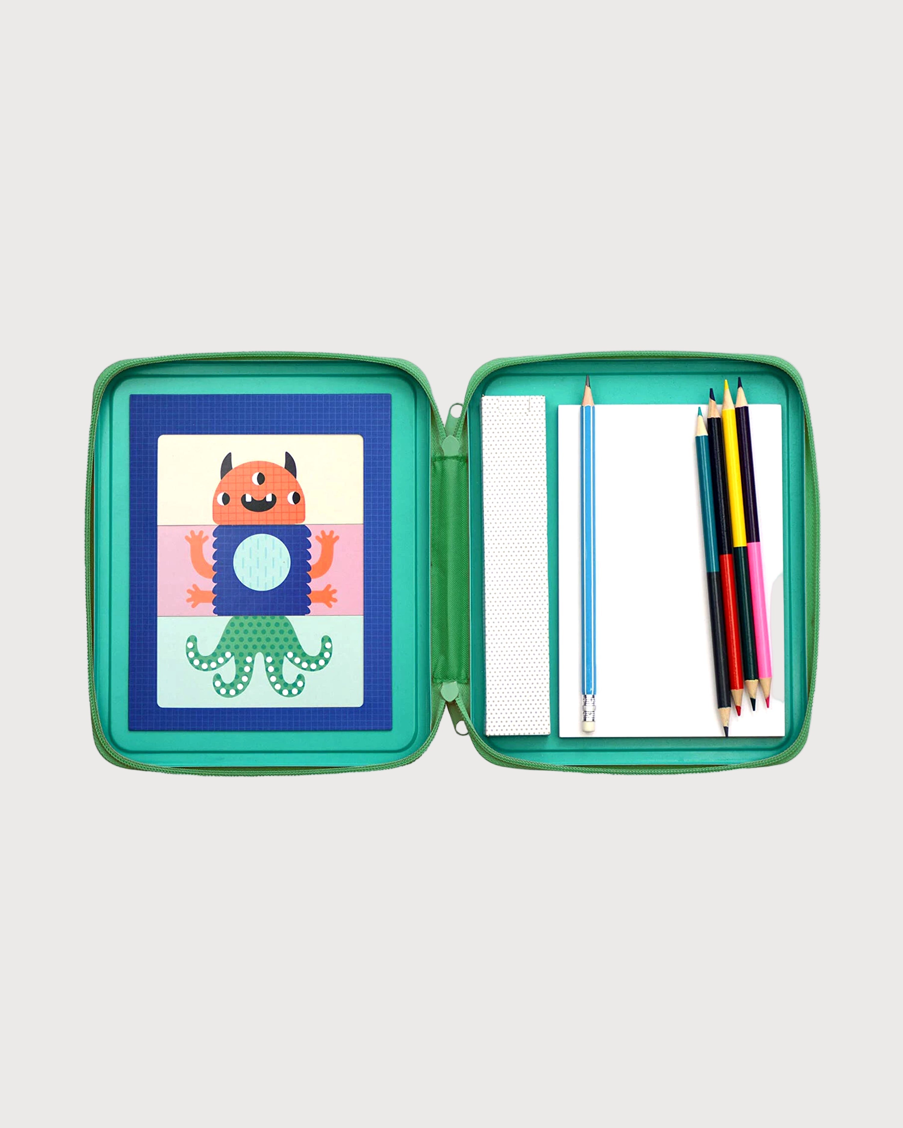 Green pencil case with cartoon monster designs on paper and pencils on a white background