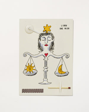 Libra Zodiac Wish Card with a hand illustrated woman forming balance scales that weigh a sun and a moon, with match, strike pad and candlewick.