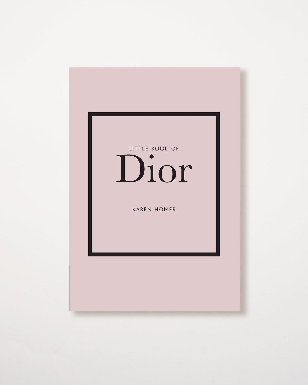 A pink book with the title 'Little Book of Dior' by Karen Homer in a black frame on the cover.