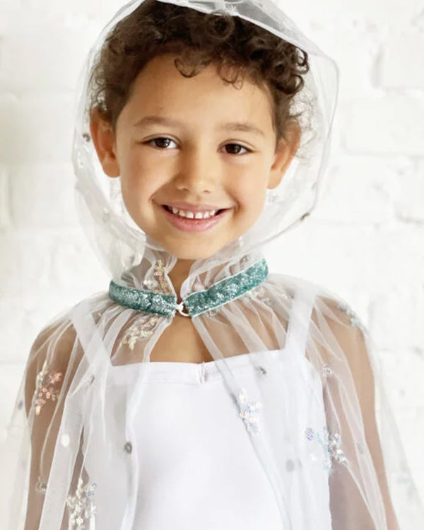Child wearing the "The Ice Princess Embroidered Cape Blue" cape on a white background