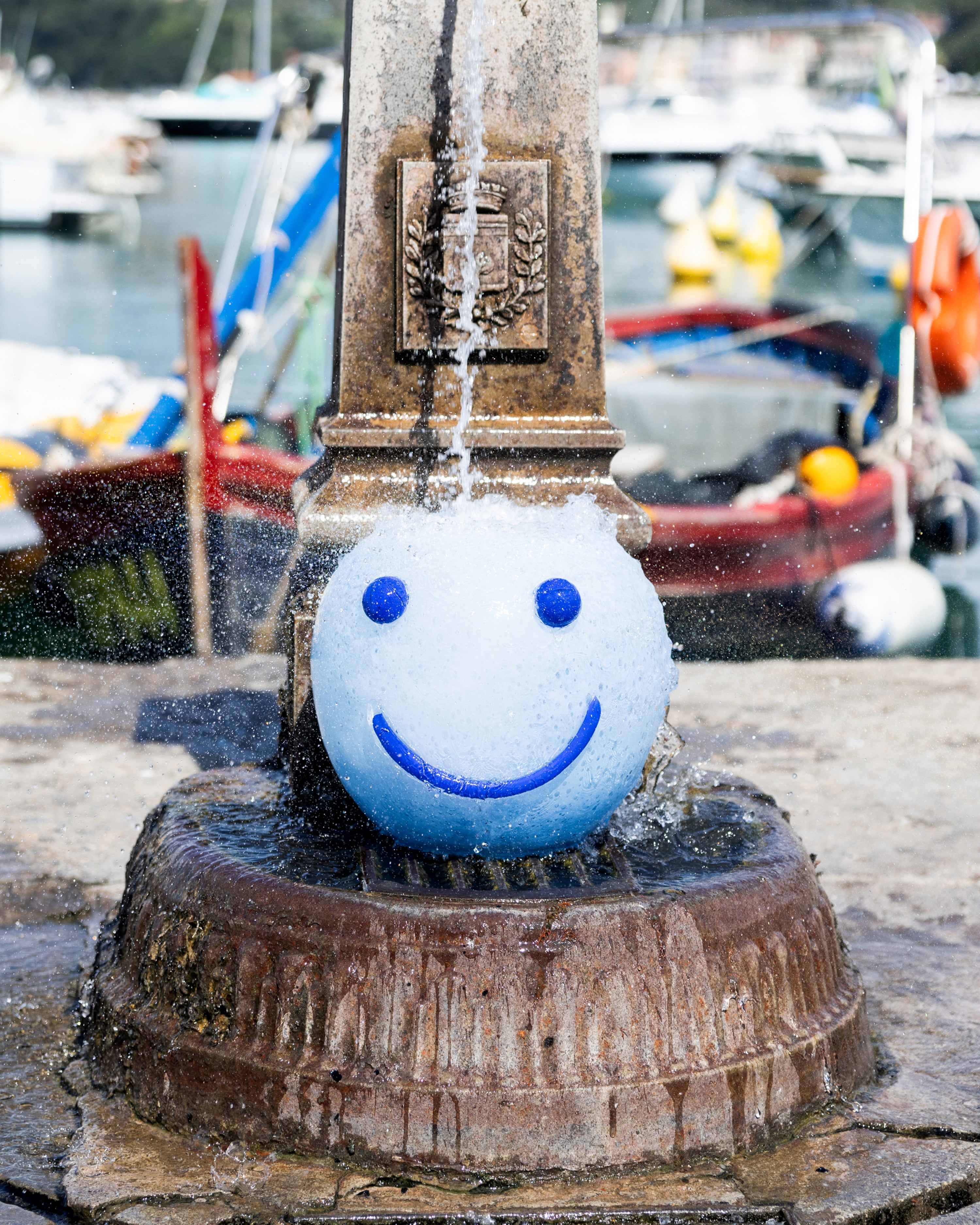Fountain with a smiley face vase in a harbor setting