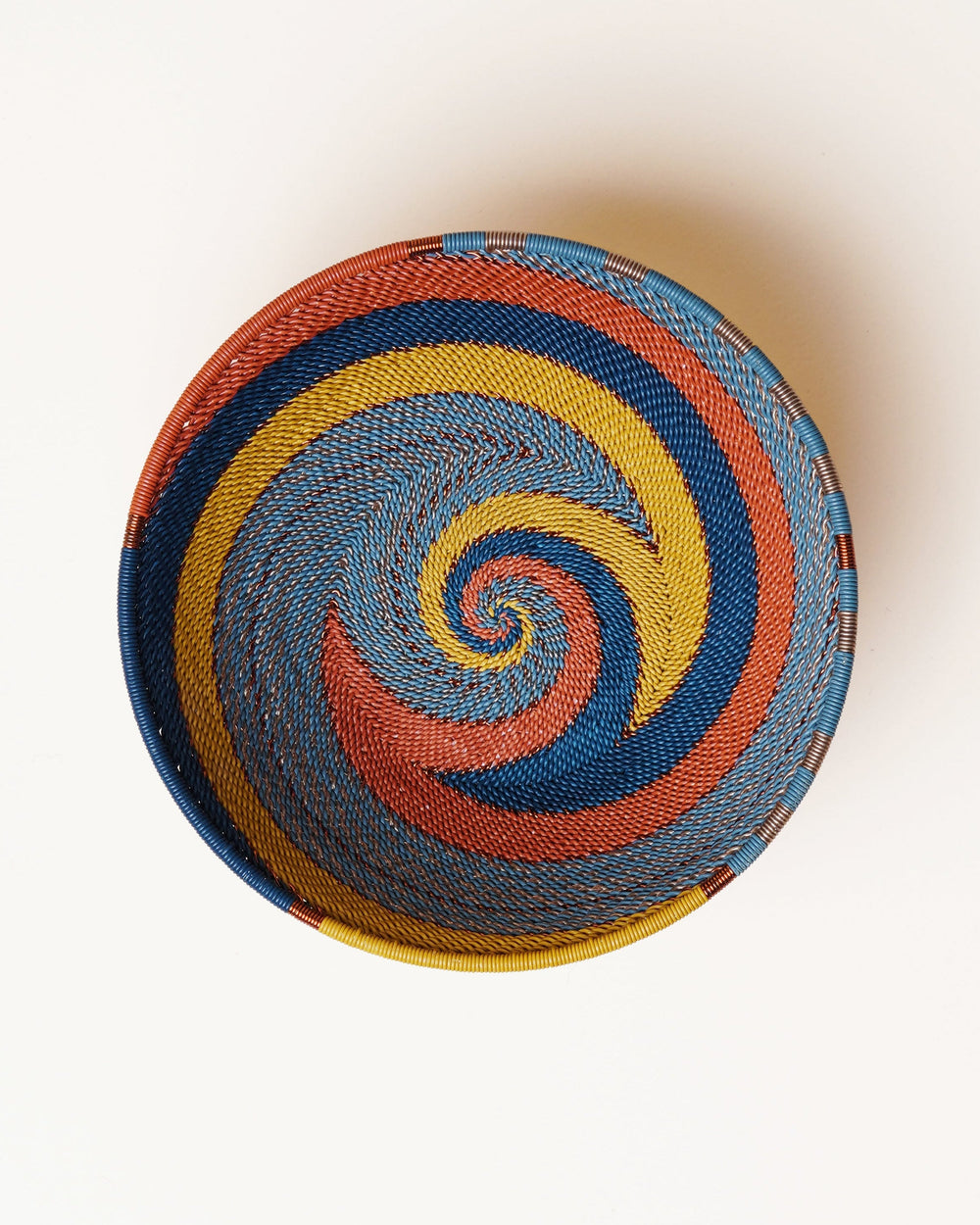 Colorful woven ball with a spiral pattern on a white background