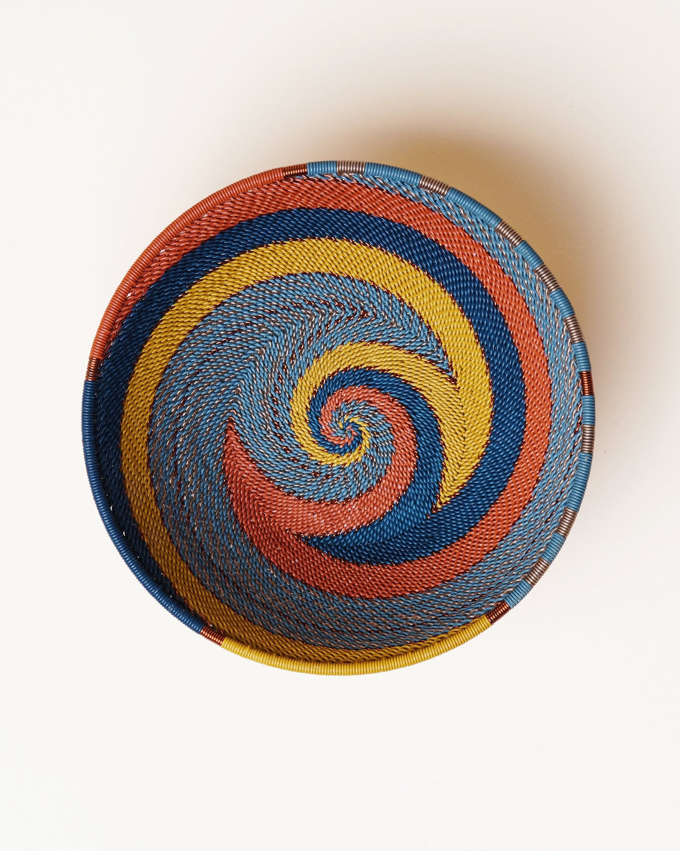 Colorful woven ball with a spiral pattern on a white background
